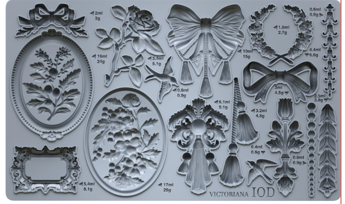 Decorative mold with various intricate designs including flowers, butterflies, and frames on a gray background.